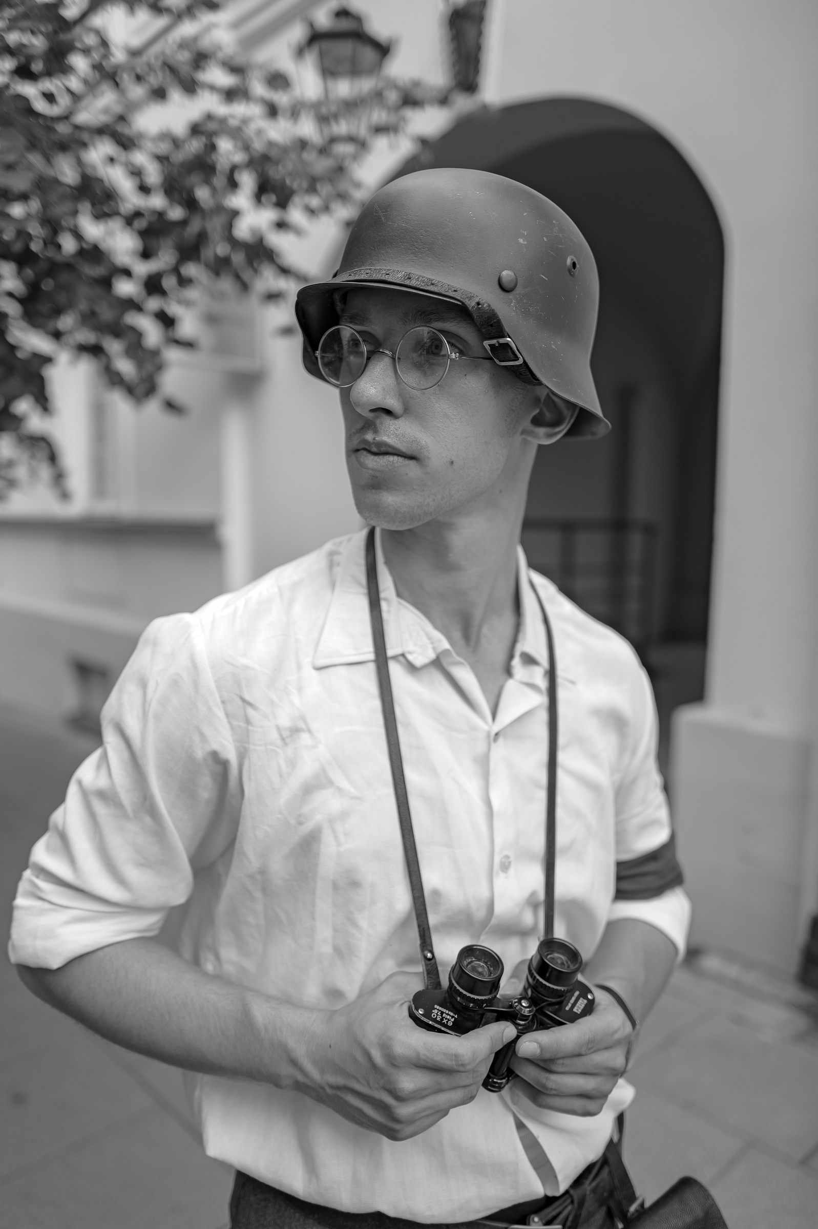 fot. Maciej Niedzielski, Czarno biały portret mężczyzny z grupy rekonstrukcji historycznej, ma na głowie hełm niemiecki, fotografia wykonana aparatem Leica Q3